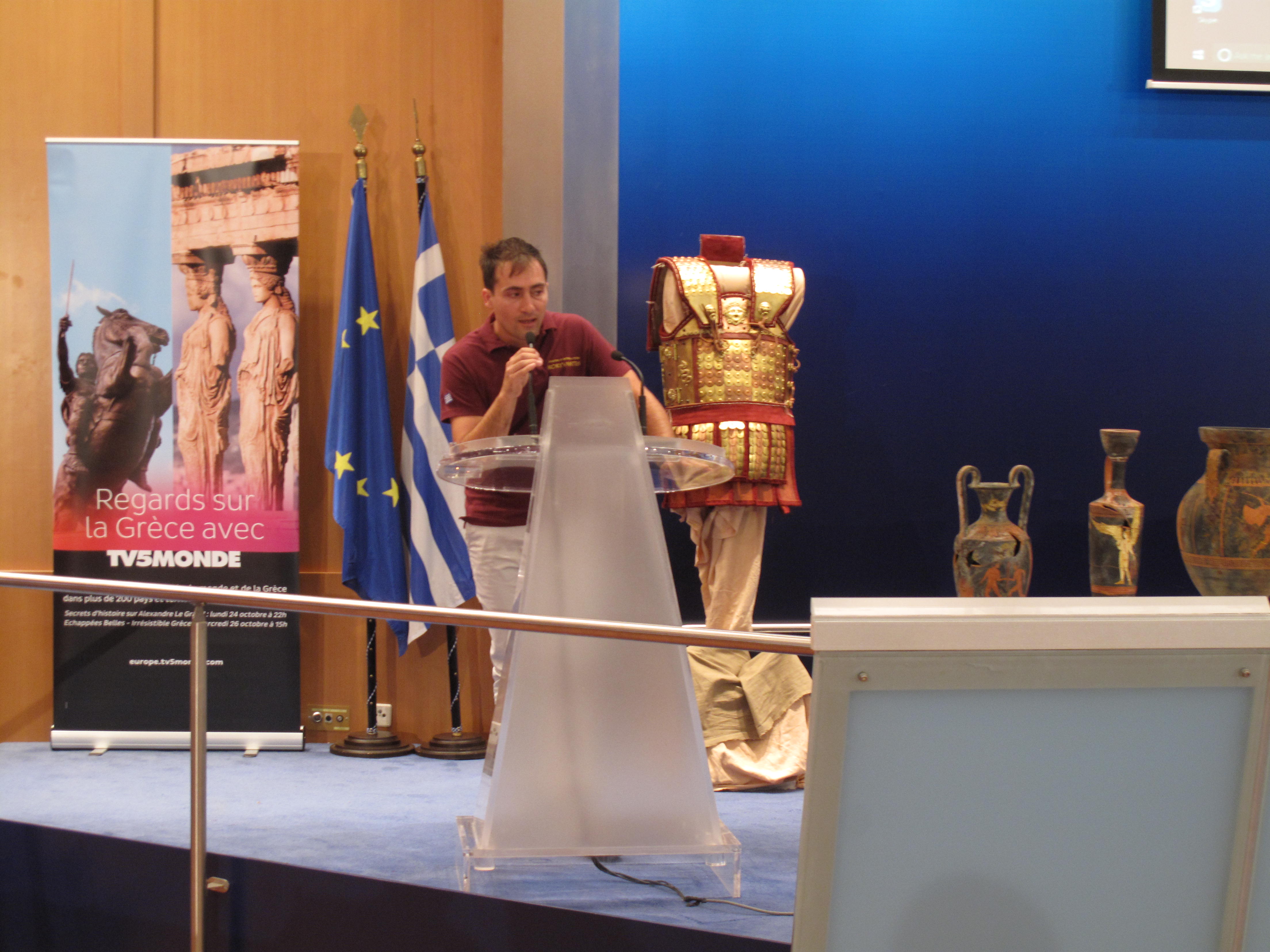 Georgios Katsos Speaking Beside Reconstructed Armour Georgios Katsos speaking to an audience beside reconstructed historical armour in Greece