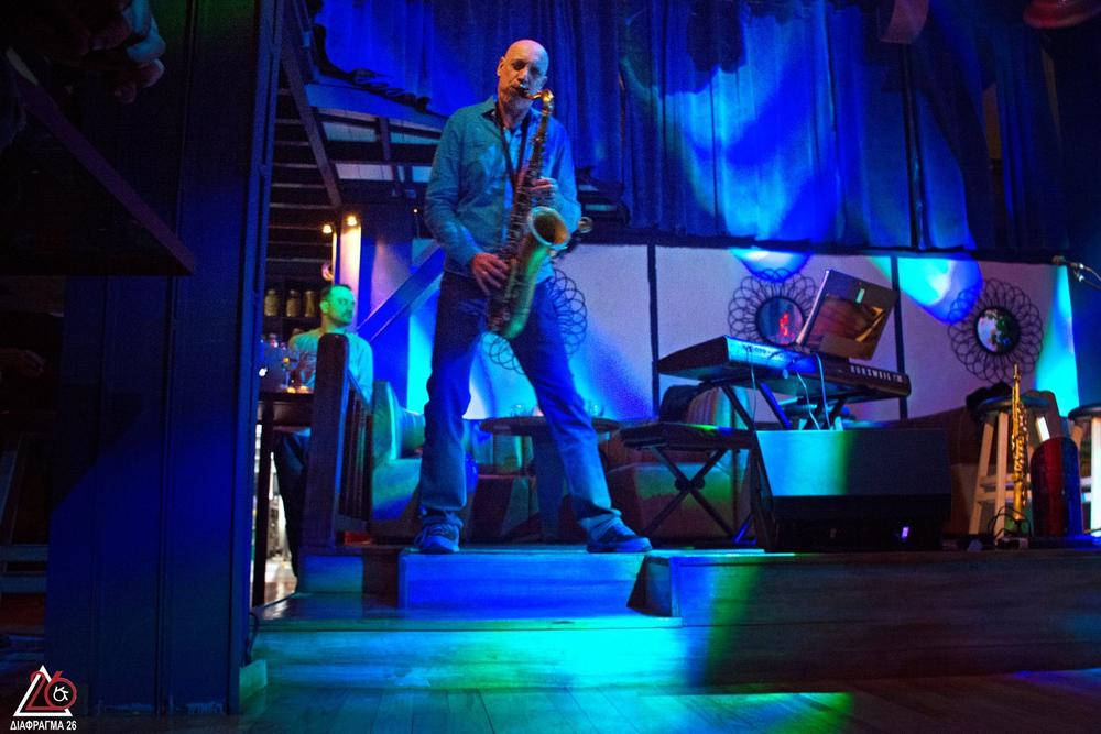 Male musician performing on a blue-lit theatrical set with reconstructed instruments