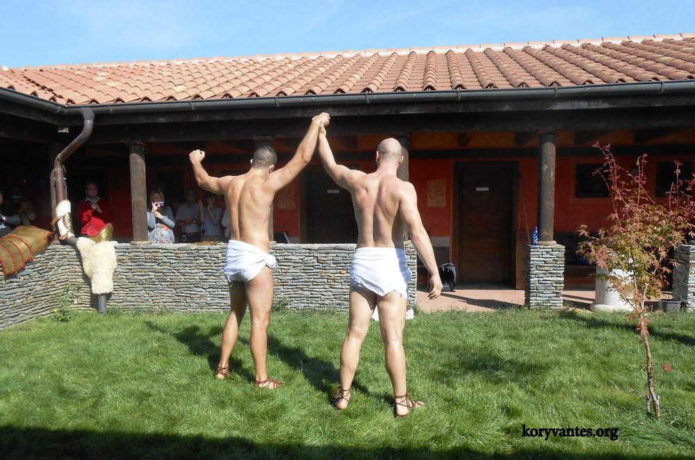 Two male athletes completing a pankration demonstration with raised joined hands