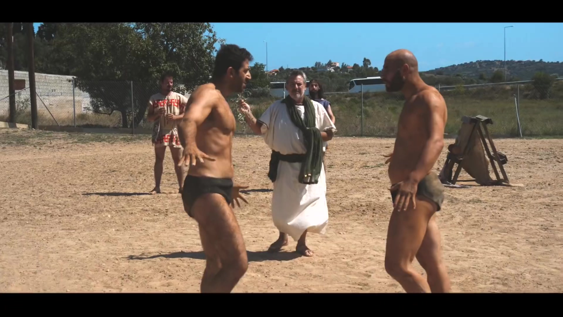 Pankration athletes and an interpreter pausing at the end of a demonstration sequence