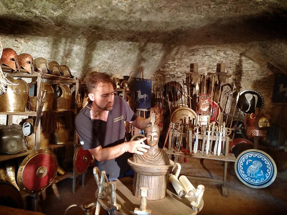 Camera operator filming a potter at work inside a historical workshop set