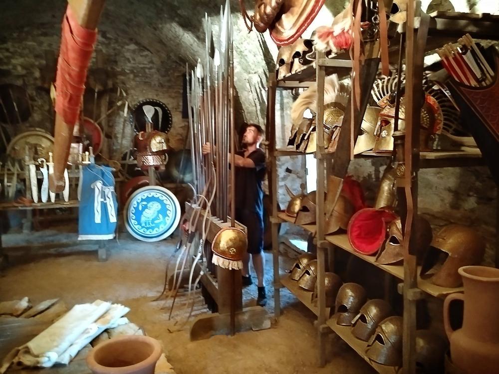 Immersive artisan shop interior filled with pottery, shields, tools and hanging goods