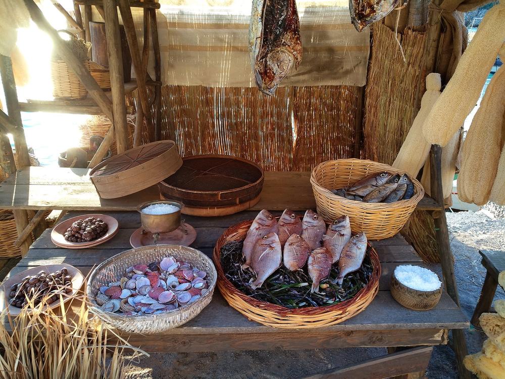 Historical fish stall with whole fish, bowls, baskets and weighing equipment