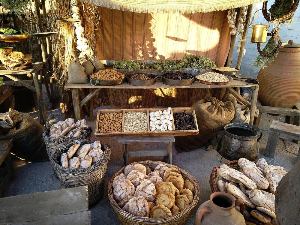 Historical stall densely arranged with breads, nuts and dry goods in baskets