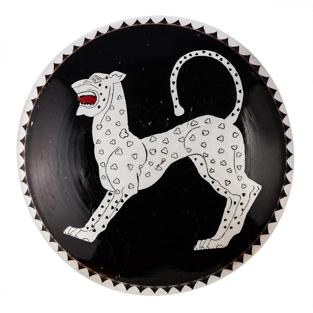 Round black shield painted with a white spotted dog emblem