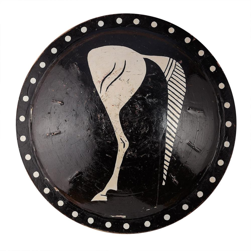 Round black shield painted with a stylised white horse emblem