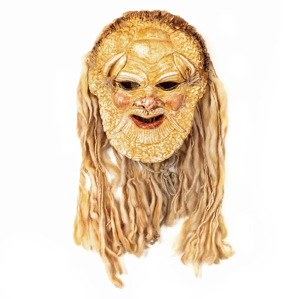 Golden bearded character mask surrounded by long pale fibre hair