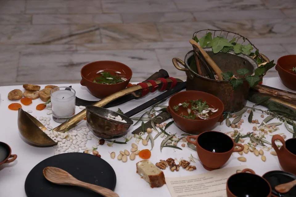 Ancient Greek-inspired tableware arranged with food as a historical dining reference