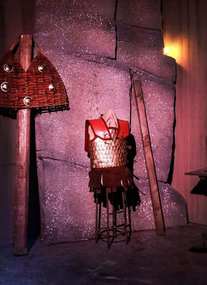 Reconstructed armour and a woven display element installed against a monumental stone-effect set inside the Gods of Olympus thematic park