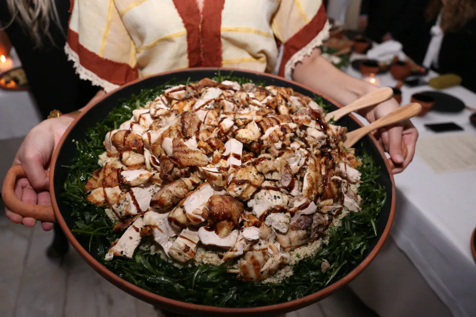 Large serving platter of chicken, wheat and wild greens for the documented myma main course