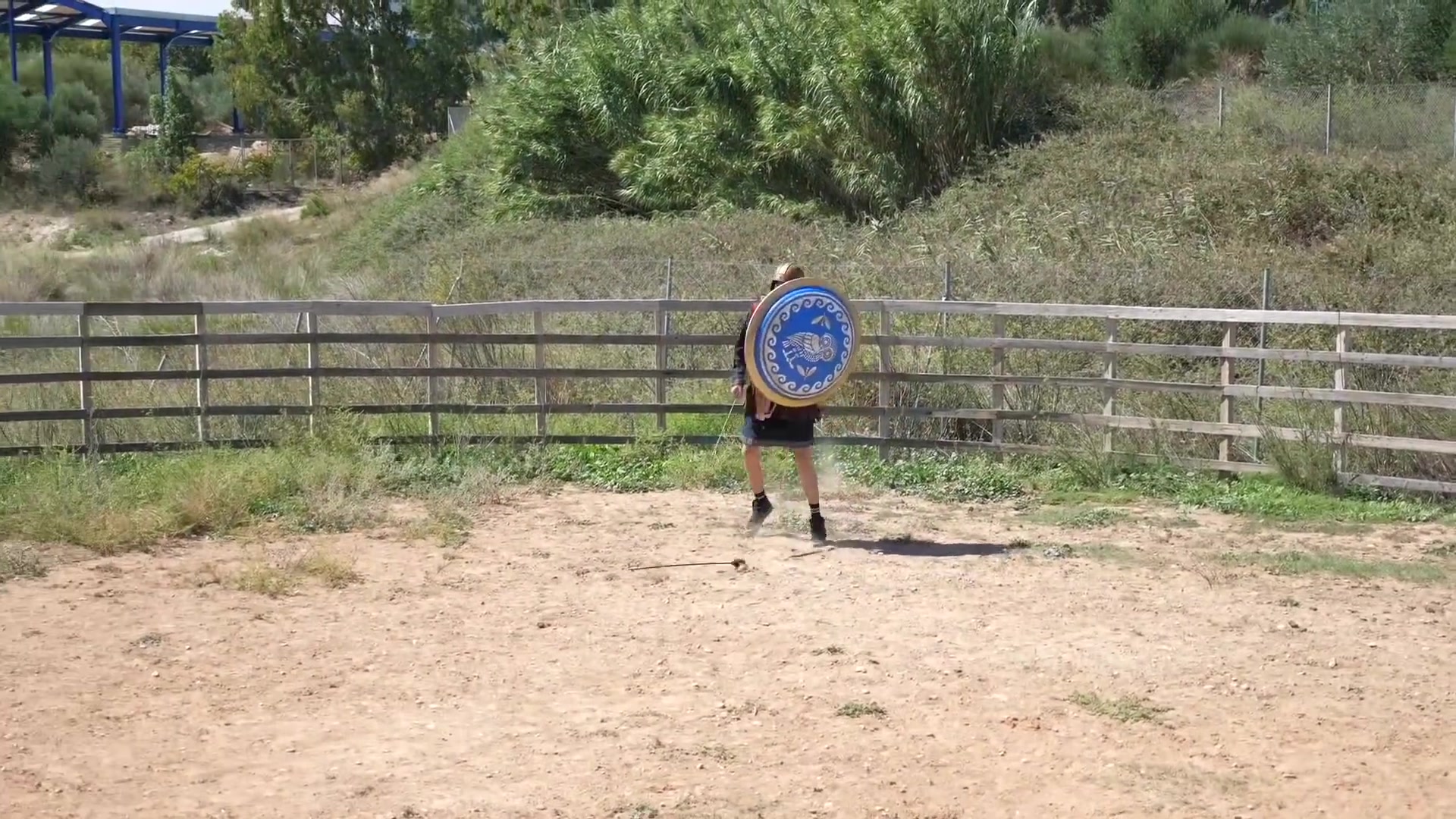 Owl-emblem shield at the range | Archaeopolis Archery Games Round blue owl shield positioned as a target in the arena