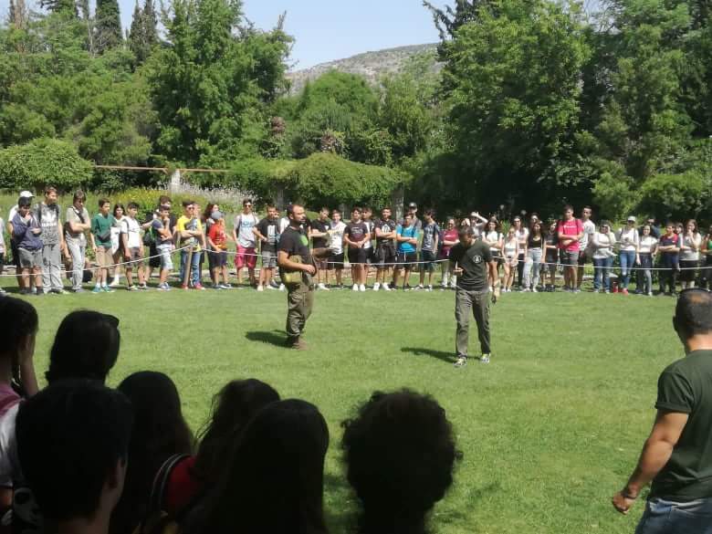 Audience surrounding the open flight area during an Archaeopolis birds of prey presentation