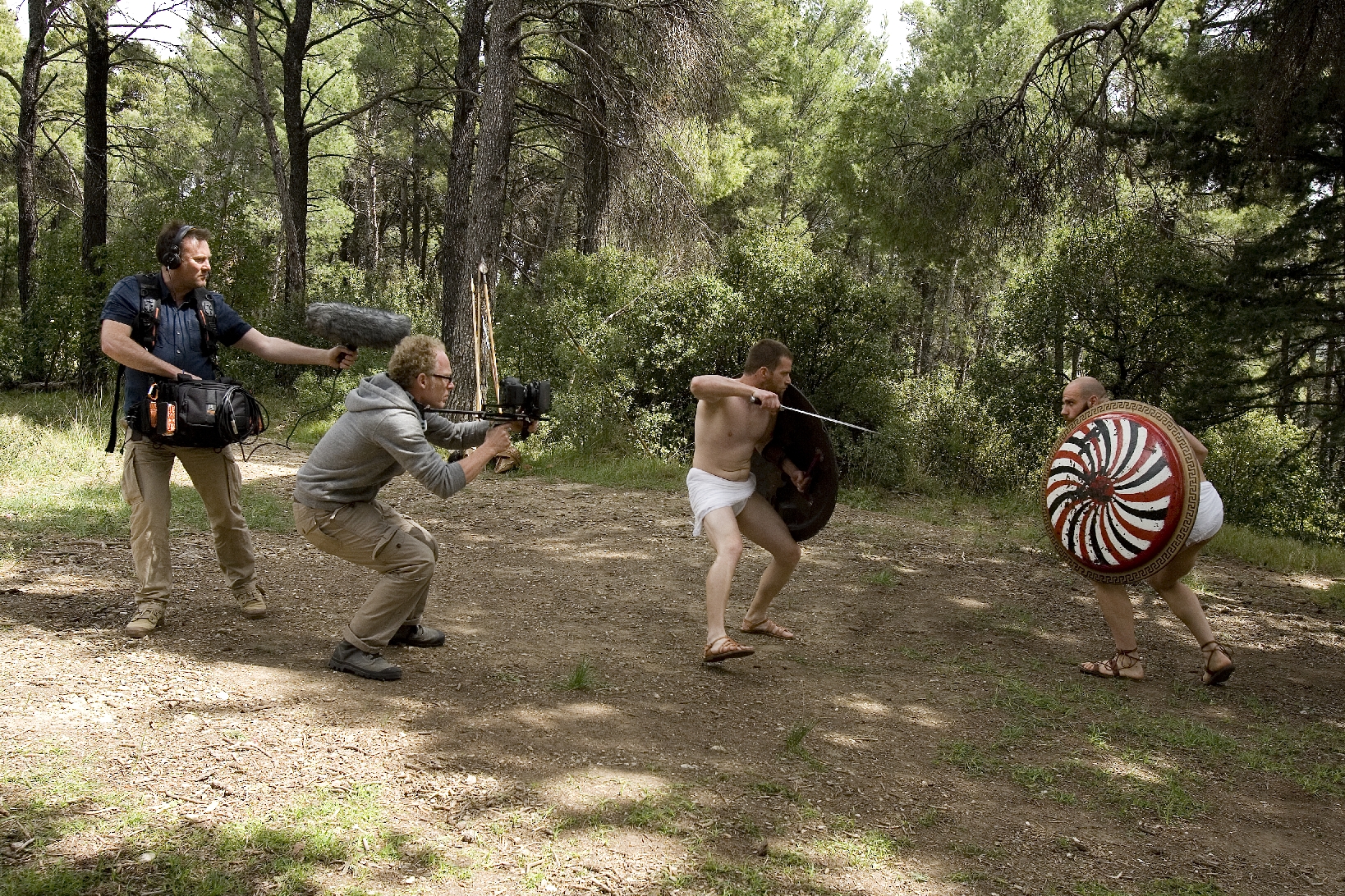 BBC camera and sound crew filming two reconstructed Greek hoplites during a combat sequence in a forest in Attica