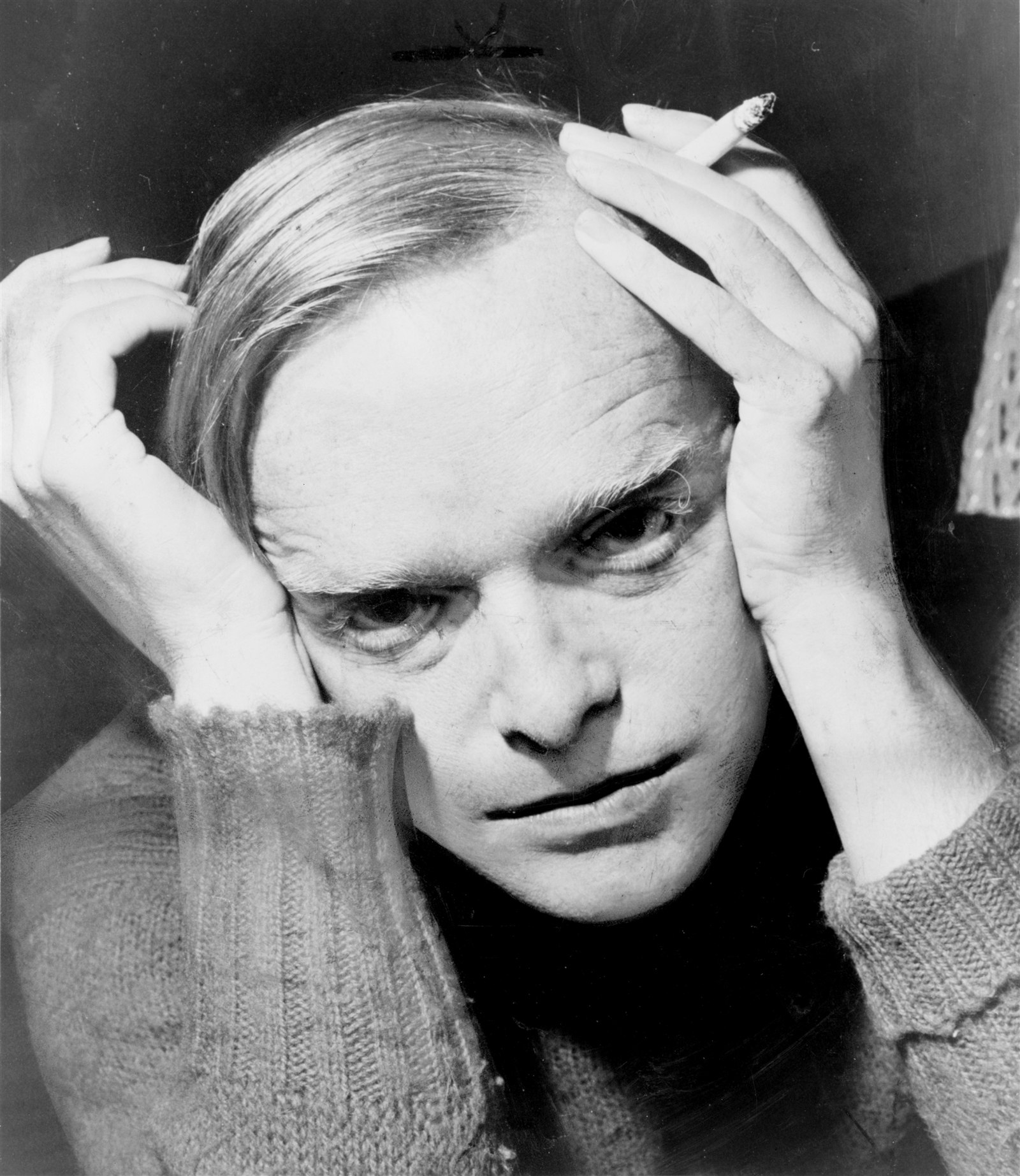 Truman Capote, 1959 Black and white portrait of Truman Capote holding his head in his hands in 1959
