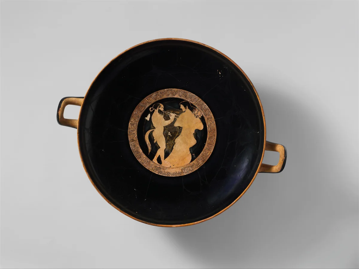 Attic red-figure terracotta drinking cup decorated with symposium scenes
