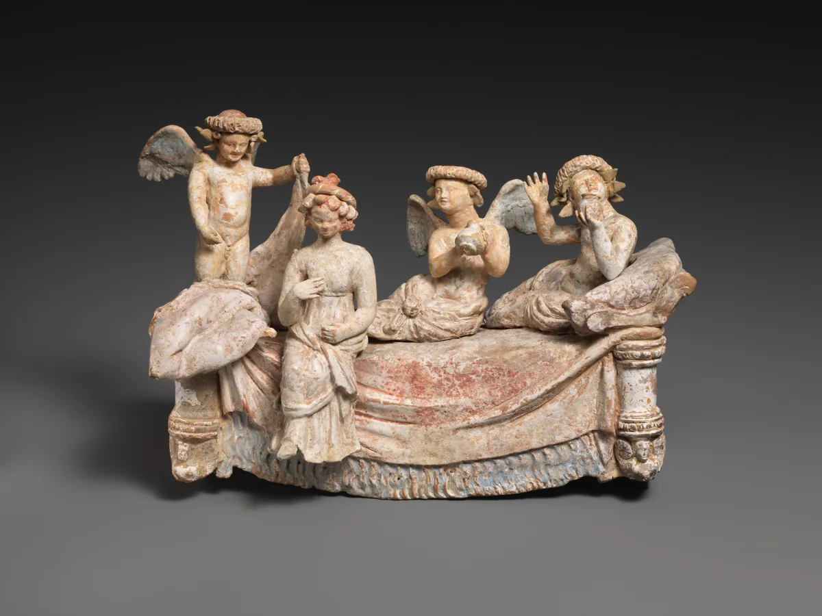 Hellenistic terracotta banquet group with a reclining couple, lyre and wine jug