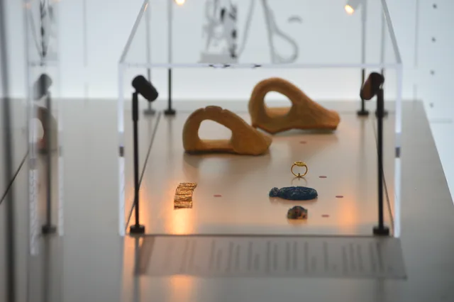 Two large terracotta fragments displayed with a ring and small blue and gold-coloured ornaments.