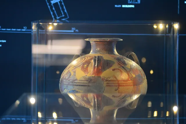 Large multicoloured painted ceramic vessel with handles and visible restored sections.