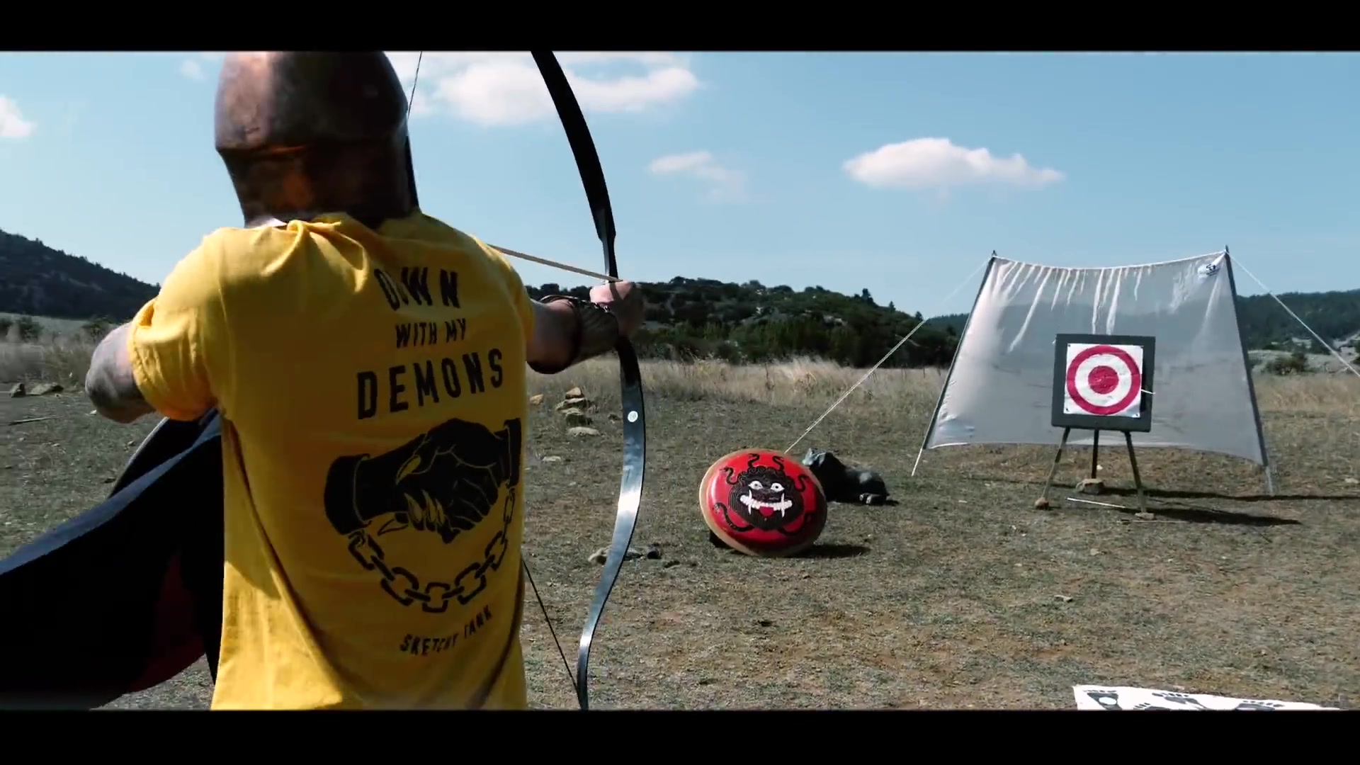 Participant aiming a bow at an outdoor target