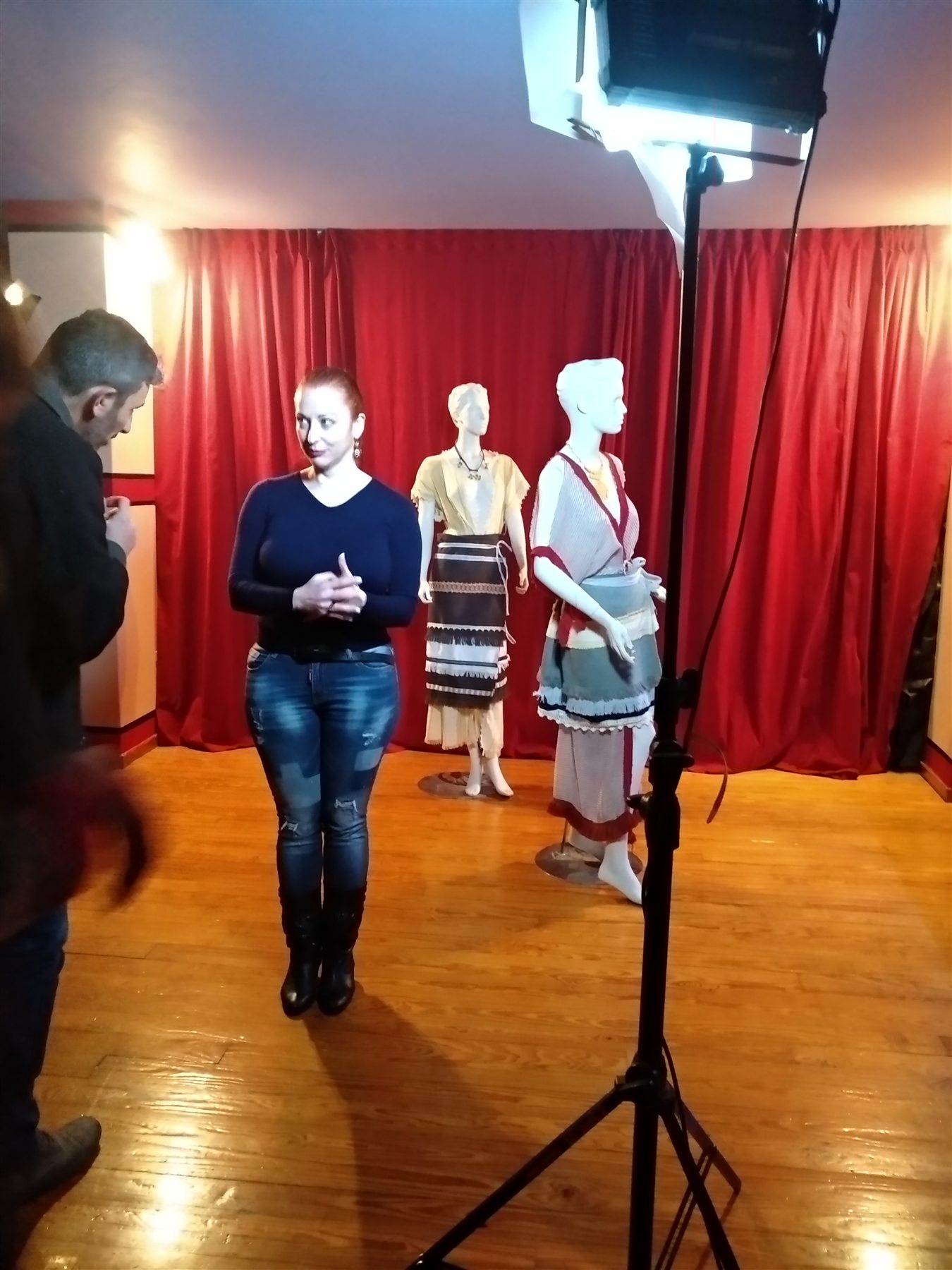 COSMOTE Ancient Greek Dress filming — 005 Female presenter standing before two mannequins wearing reconstructed ancient Greek dress