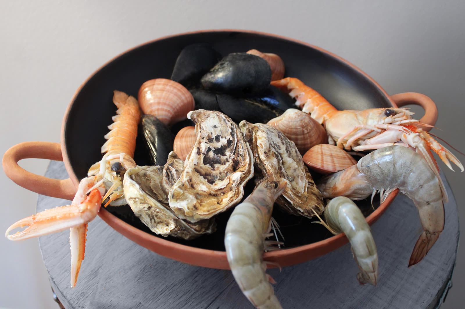 Mixed shellfish arranged in a terracotta vessel for the Archaeopolis event menu