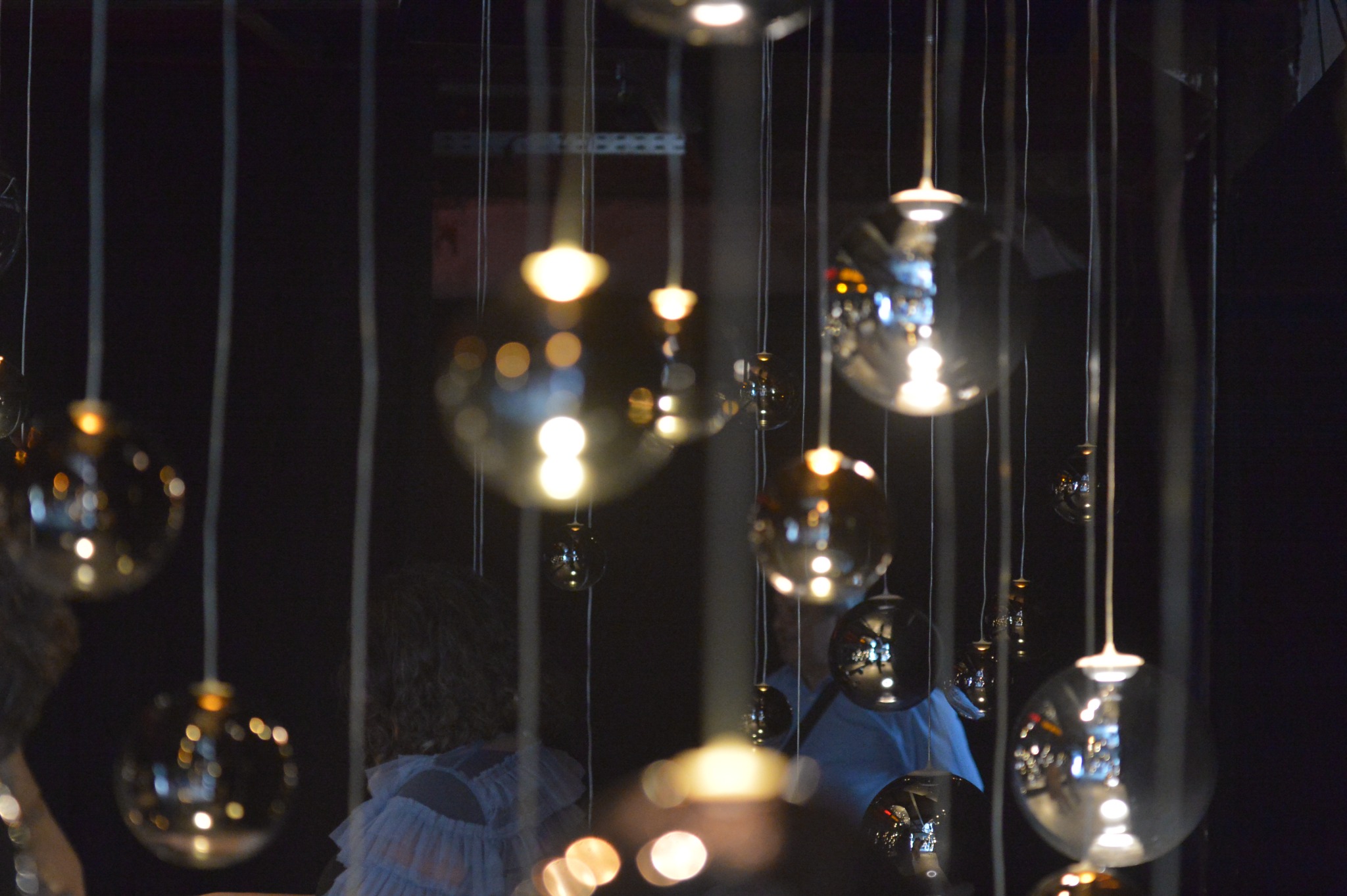 Suspended glass lights creating reflections at a private dining event in Mykonos