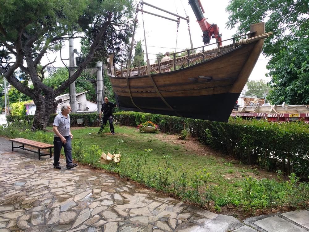 Setting the Ship in Place | Archaeopolis Olkas Ship Olkas ship suspended by crane during careful placement