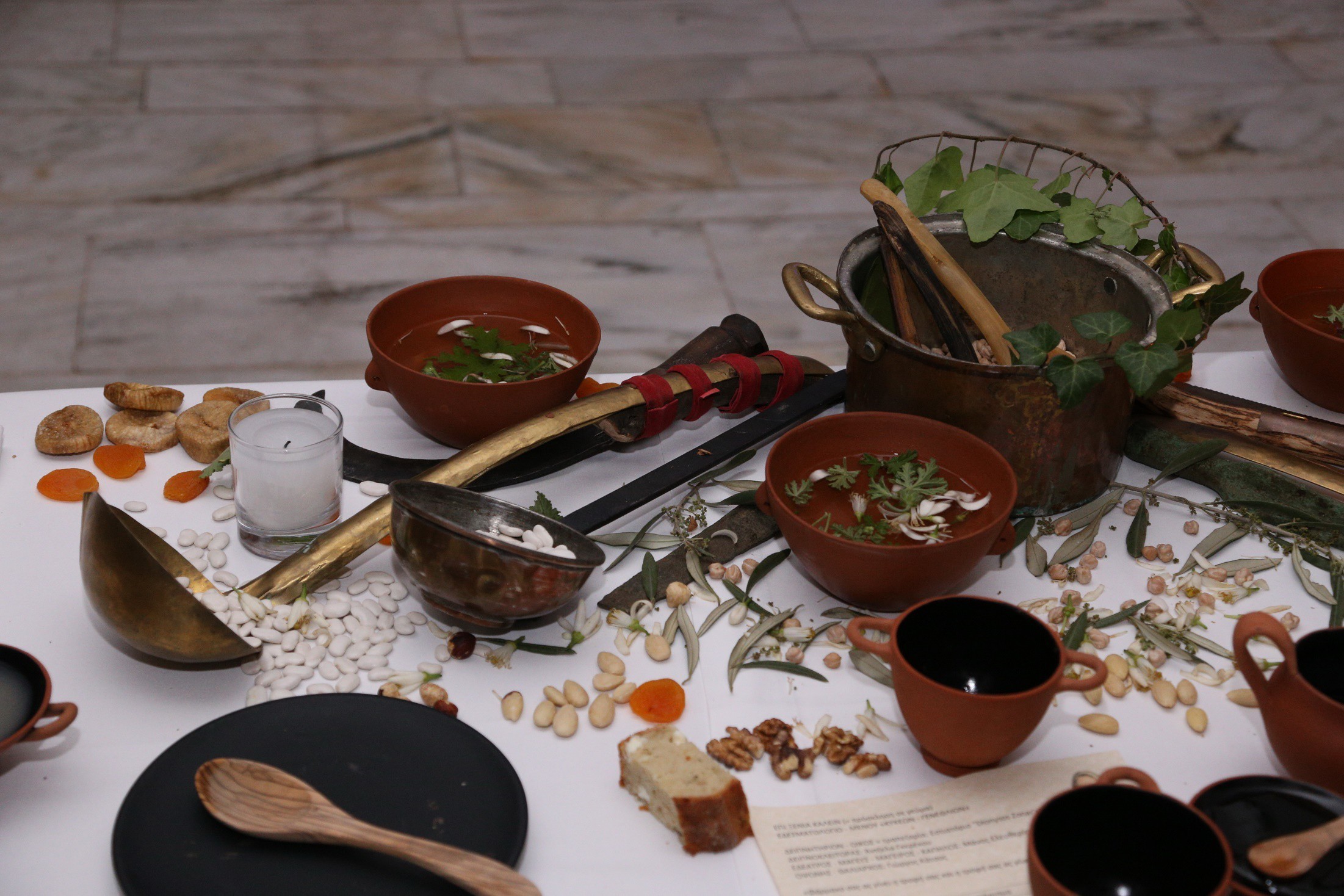 Ancient Greek-inspired tableware arranged with food as a historical dining reference