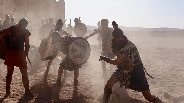 Armed performers carrying shields in a reconstruction scene from The Mystery of the Trojan Horse