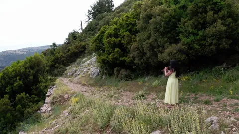 The Navel of the World publicity still with a woman among the green hills at Delphi