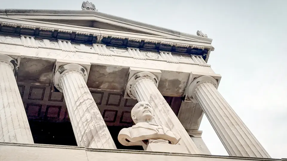 Official programme still from Troy Story: The Schliemann Legacy showing a neoclassical facade and statue